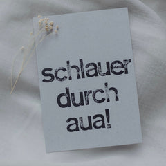 Postkarte "Schlauer durch aua" gestempelter Spruch